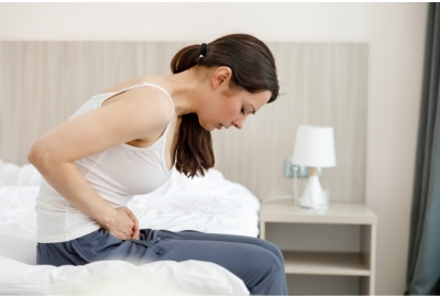 lady sitting on bed in pain