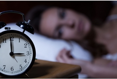 insomnia woman looking at clock from bed