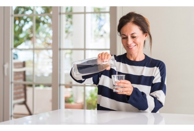 middle aged woman drinking glass water