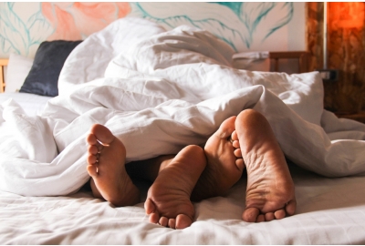 couple's feet intertwined in bed