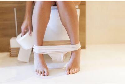 womans legs sitting on toilet