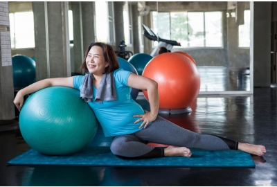 woman doing on yoga mat with exercise ball