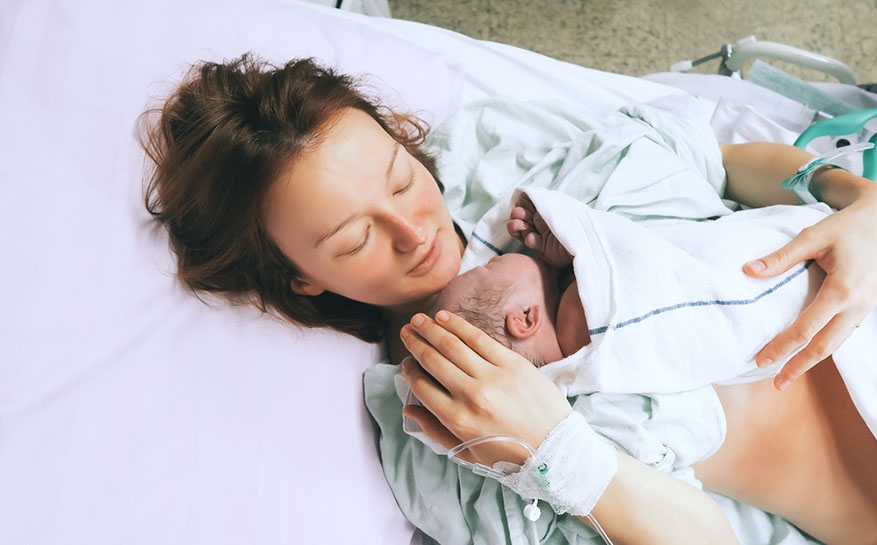 mother holding newborn after birth