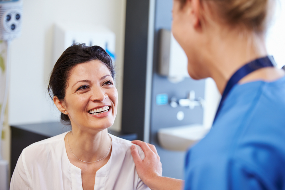 woman sitting looking up at doctor