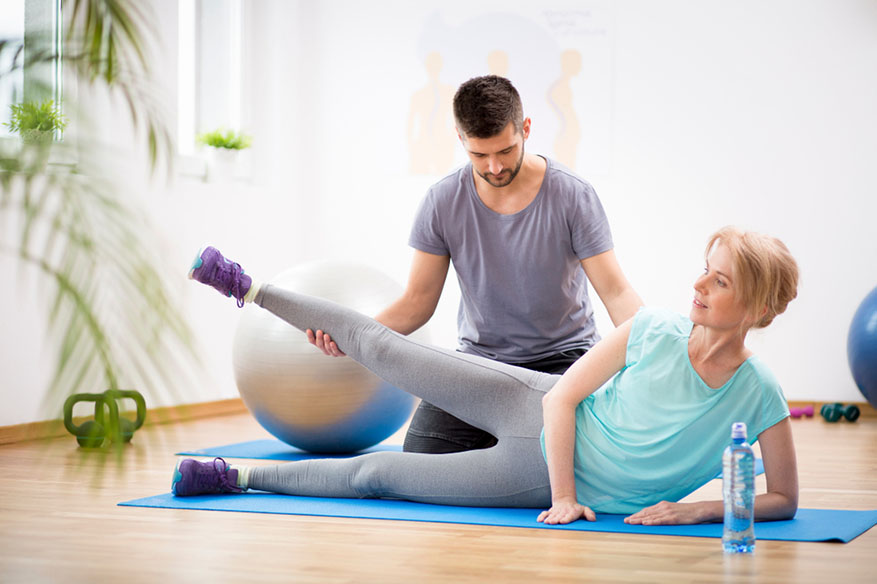 trainer stretching with woman