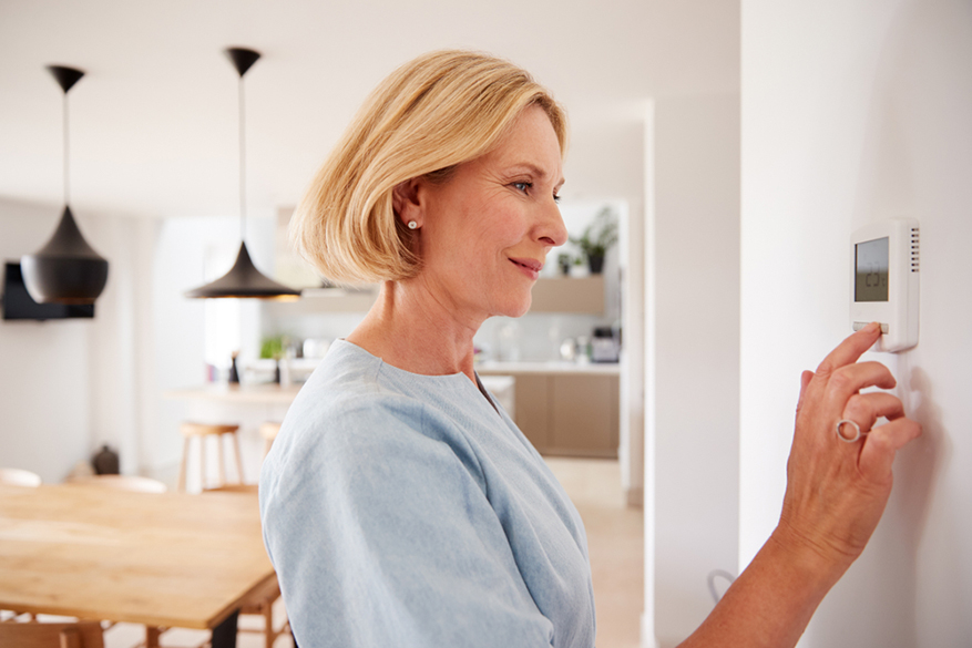 woman adjusting central ac