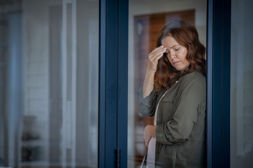 woman rubbing brow in stress