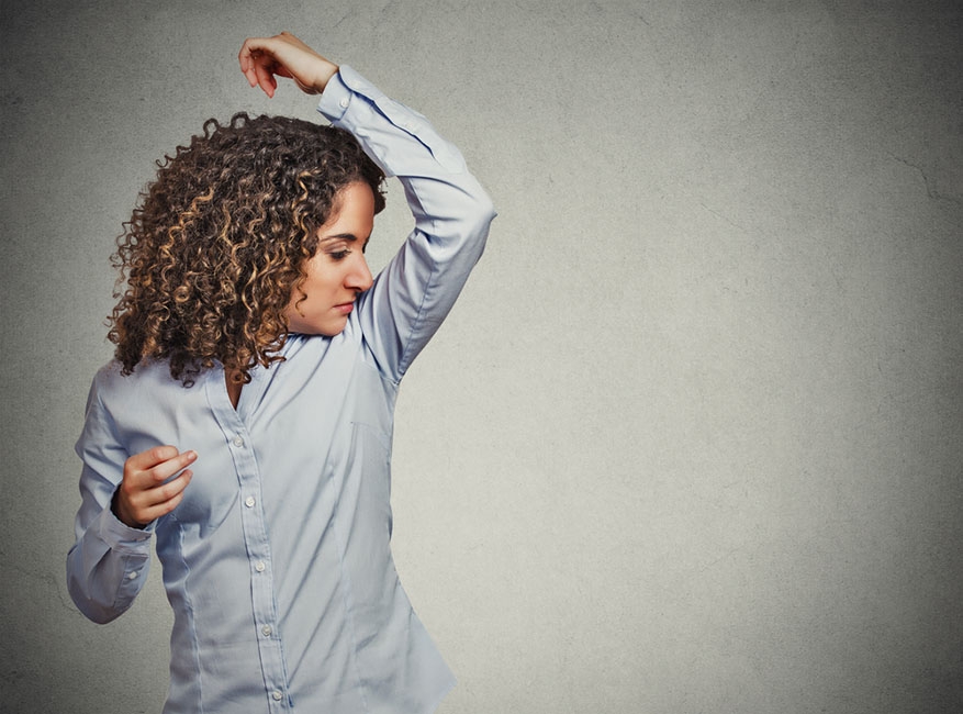 young woman smelling armpit